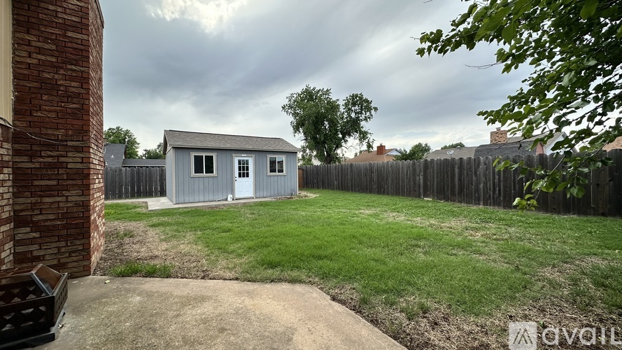 A backyard with a shed and a fence.