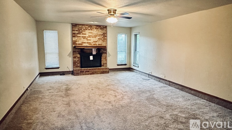 A room with a fireplace and a ceiling fan.