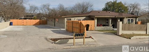 A house with a brown fence and a sign that says "available" in front of it.