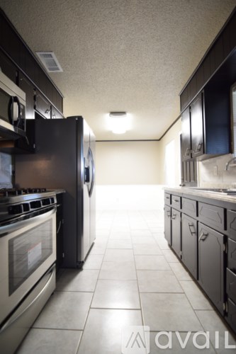 A kitchen with black cabinets and stainless steel appliances.