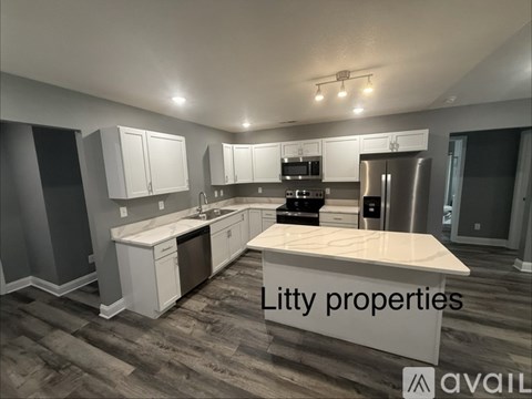 A modern kitchen with a white island and stainless steel appliances.