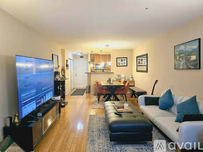 A living room with a television, a couch, and a dining table.