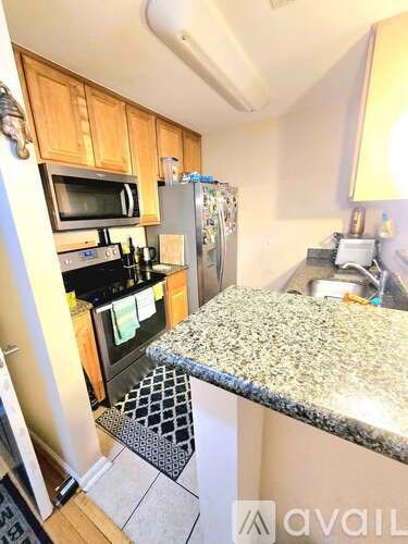 A kitchen with granite countertops and a refrigerator.