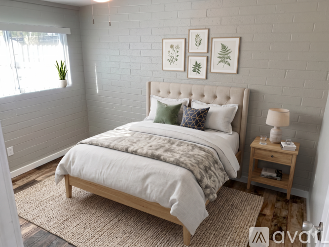 A bedroom with a large bed and a wooden nightstand.