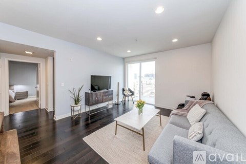 A living room with a grey couch and a wooden coffee table.
