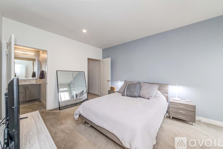 A bedroom with a large bed, a dresser, and a mirror.