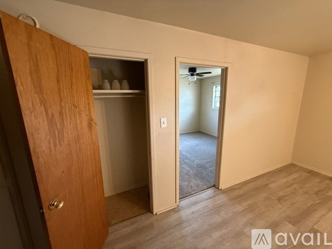 A room with a wooden door and a carpeted floor.