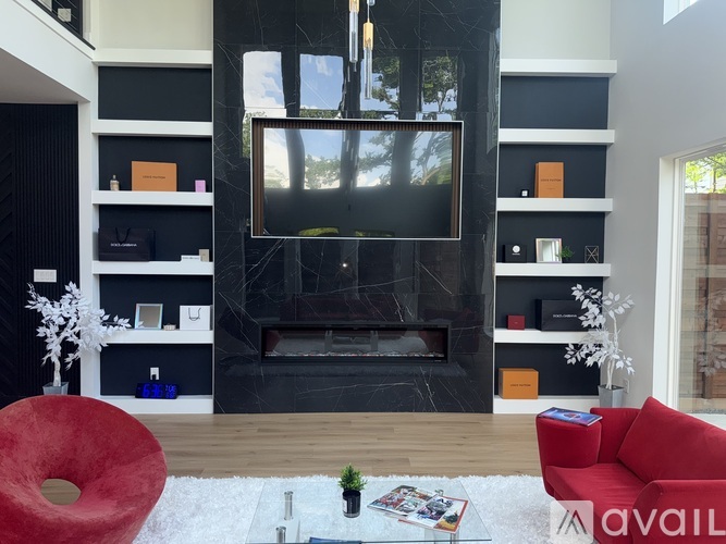 A living room with a red couch and a fireplace.