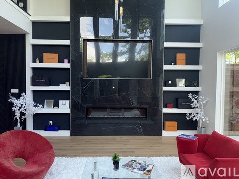 A living room with a red couch and a fireplace.