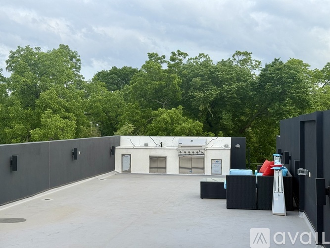 A rooftop with a white building, black boxes, and a few people standing.