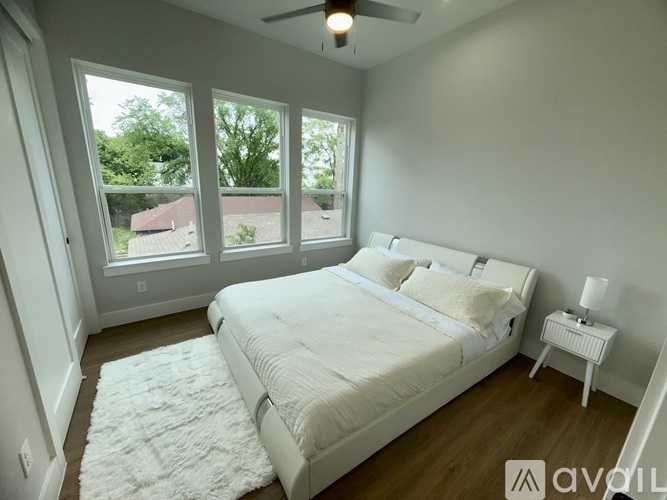 A bedroom with a large bed and a ceiling fan.