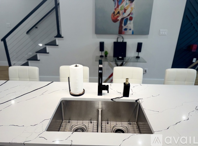 A kitchen counter with a sink and a bottle of oil on it.