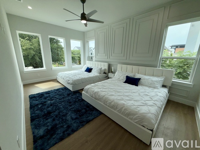A bedroom with two beds and a ceiling fan.