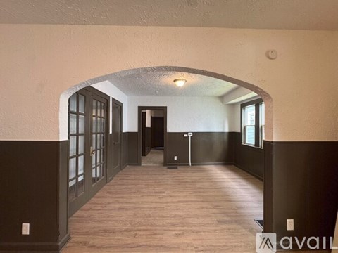 A hallway with a brown floor and walls, and a white ceiling.