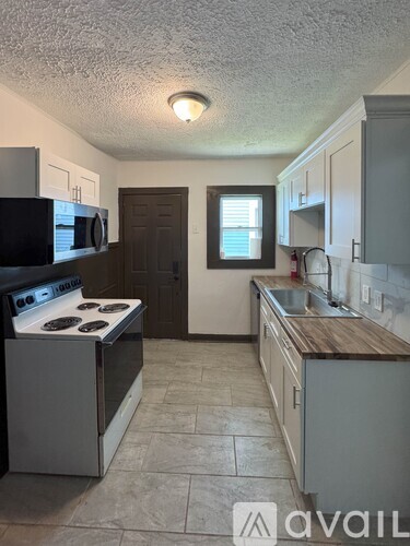 A kitchen with a stove, microwave, and cabinets.