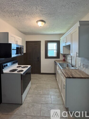 A kitchen with a stove, microwave, and cabinets.