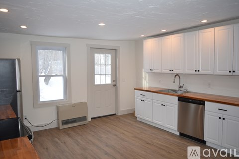 A kitchen with white cabinets and a wooden countertop.