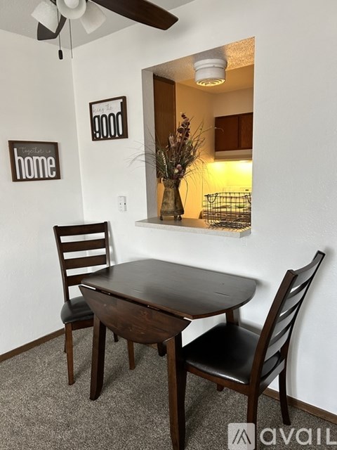 A dining room with a table and chairs.