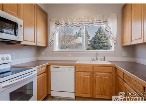 A kitchen with wooden cabinets and a white dishwasher.