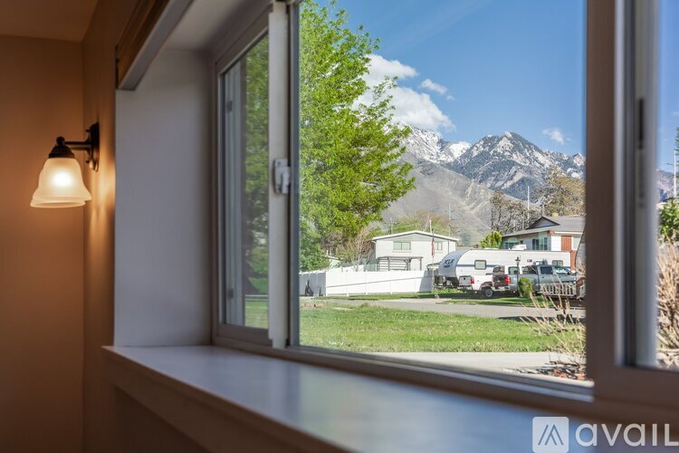 A window overlooking a residential area with houses and trees.