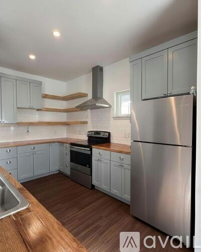 A modern kitchen with a stainless steel refrigerator and wooden countertops.