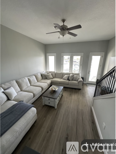 A living room with a long couch and a ceiling fan.
