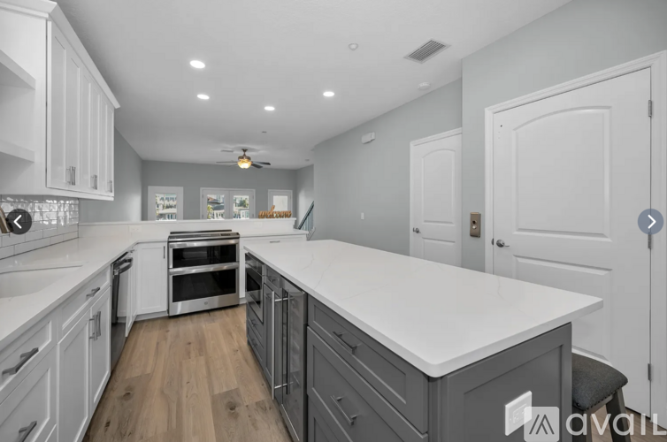 A modern kitchen with white cabinets and a large island.