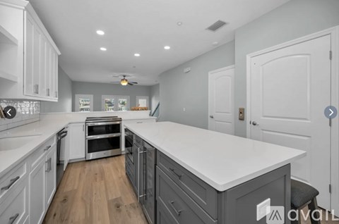 A modern kitchen with white cabinets and a large island.