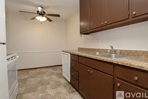 A kitchen with brown cabinets and a beige floor.