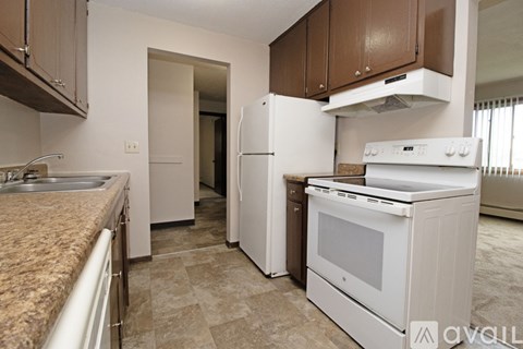 A kitchen with brown cabinets and a white stove top oven.