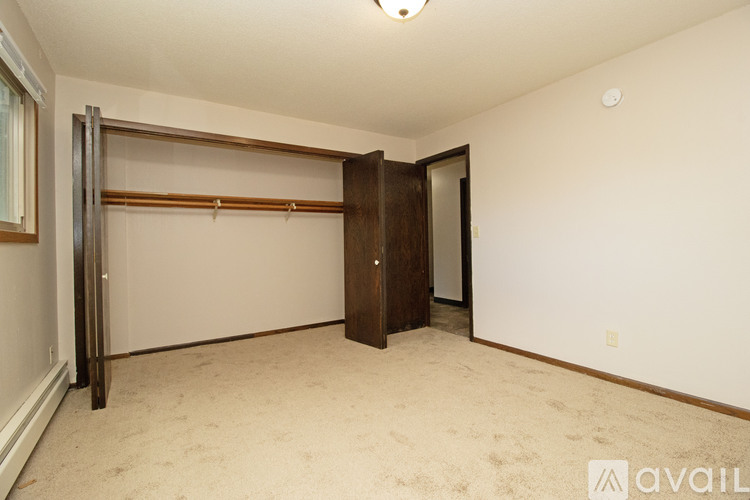 A bedroom with a sliding door and carpeted floor.