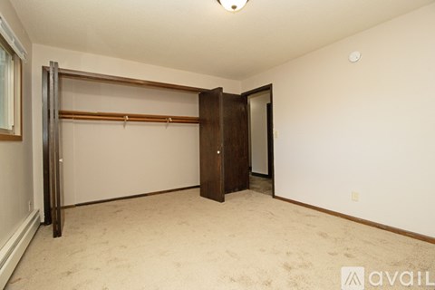 A bedroom with a sliding door and carpeted floor.