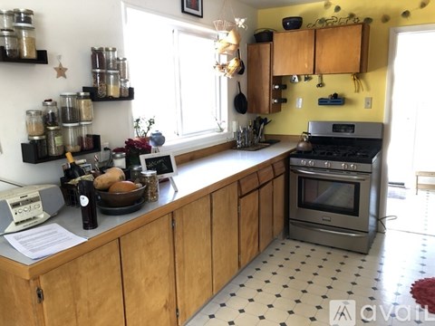 A kitchen with wooden cabinets and a black and white checkered floor.