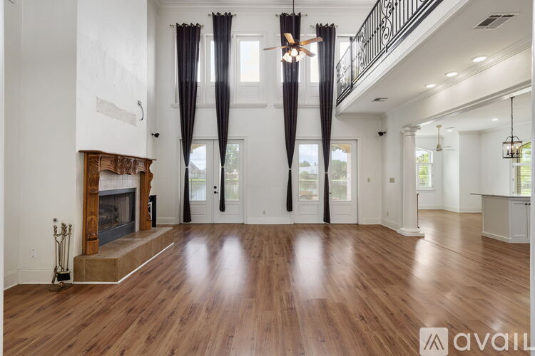 A spacious living room with wood flooring and a fireplace.