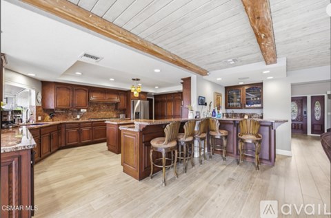 A large kitchen with wooden cabinets and a bar area.