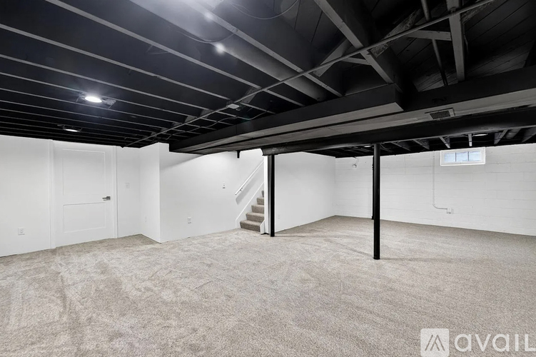 A spacious room with a staircase and a carpeted floor.