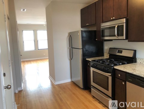 A kitchen with a black refrigerator, stove, and microwave.