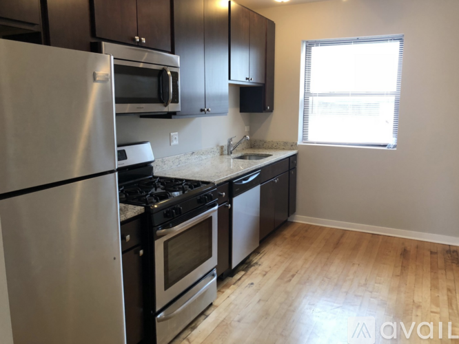 A kitchen with a stainless steel refrigerator, microwave, oven, and dishwasher.