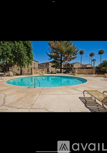 A pool surrounded by a concrete patio and a fence.