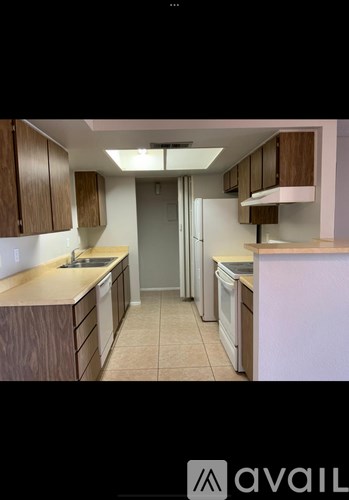 A kitchen with wooden cabinets and a white refrigerator.