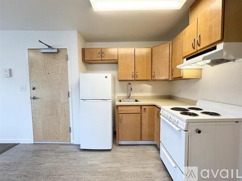 A kitchen with white appliances and wooden cabinets.