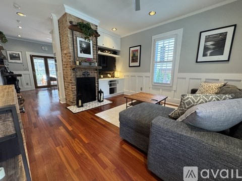 A living room with a grey couch and a fireplace.