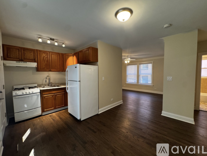 A kitchen with white appliances and wooden cabinets.