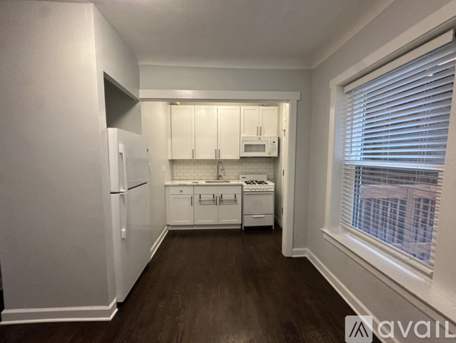 A kitchen with white appliances and cabinets.