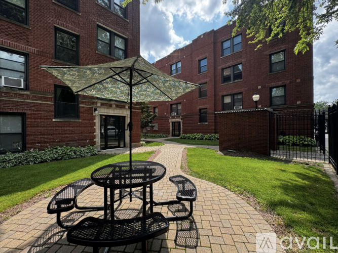 A patio with a table and chairs and a building in the background.