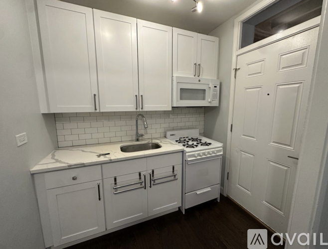 A kitchen with white cabinets and appliances.