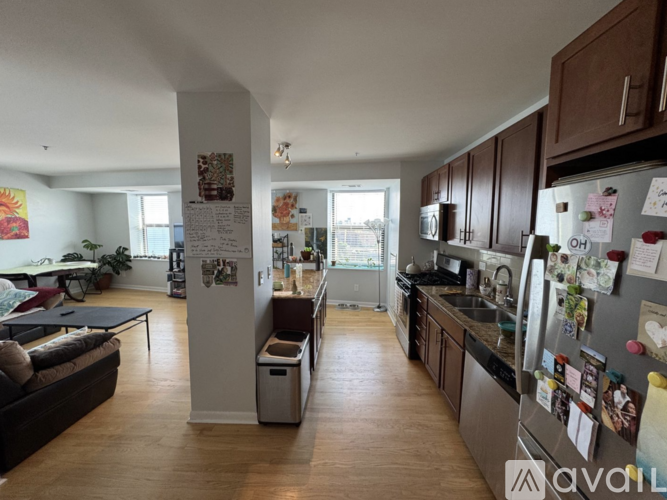 A kitchen with a refrigerator covered in magnets and notes.