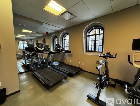 A gym with treadmills, elliptical machines, and a stationary bike.