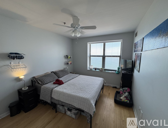 A bedroom with two beds and a ceiling fan.