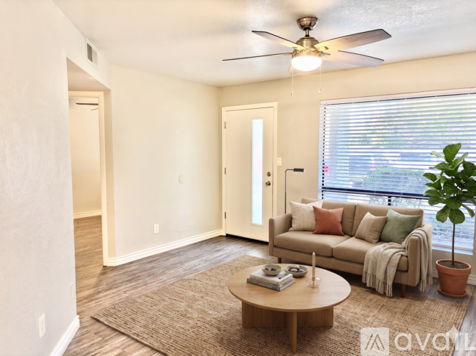 A living room with a couch, a coffee table, and a ceiling fan.